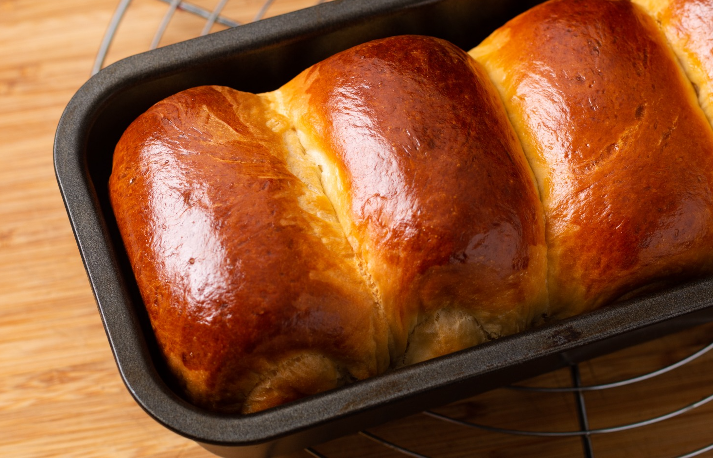 conceito-de-cozimento-de-alimentos-fresco-assado-organico-caseiro-pao-de-pao-de-leite-em-forma-de-pao-na-placa-de-madeira-com-espaco-de-copia.png
